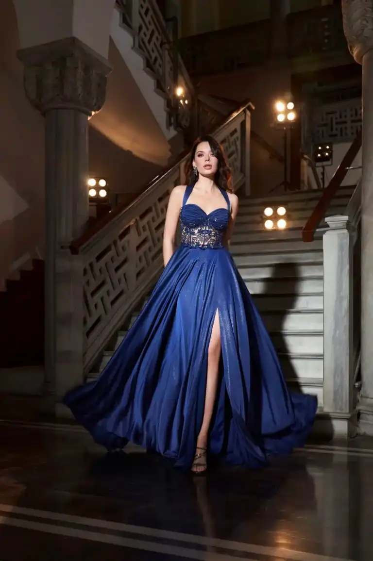 Frau mit elegantem blauen Abendkleid vor einer Treppe