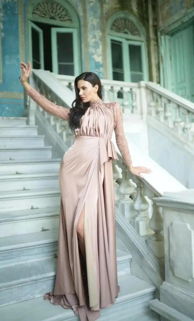 Frau mit elegantem pinkem Abendkleid vor einer Treppe