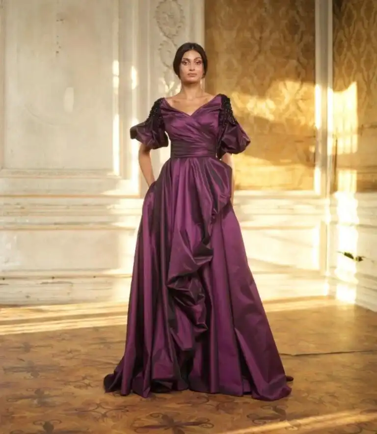 Frau mit elegantem lila Abendkleid vor einer Treppe