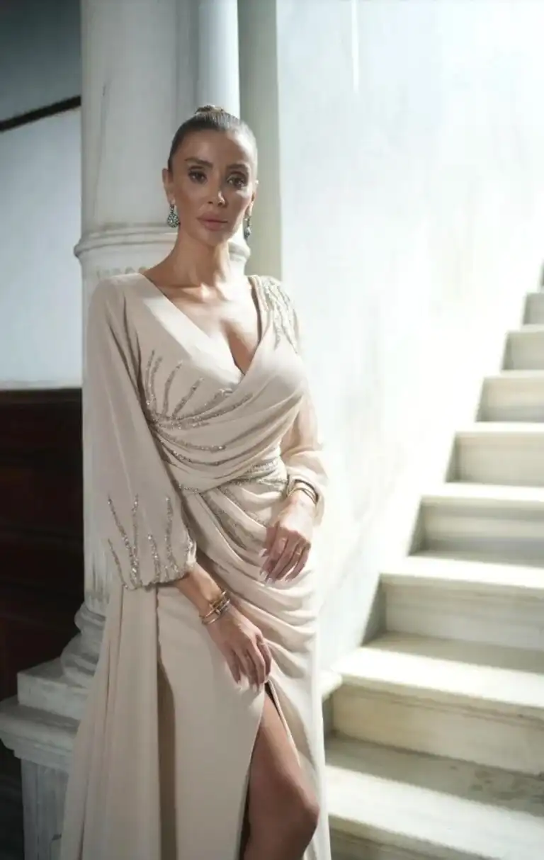 Frau mit elegantem weißen Abendkleid vor einer Treppe